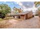 Brick ranch house with a large backyard, gravel driveway, and mature trees at 834 Brookwood Dr, Mooresville, NC 28115