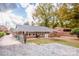 Large backyard with gravel area, mature trees, and a gas grill at 834 Brookwood Dr, Mooresville, NC 28115