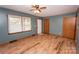 Living room with wood-look floors, ceiling fan, and large windows providing natural light at 539 Bethlehem Rd, Statesville, NC 28677