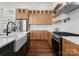 Modern kitchen with light wood cabinets, a farmhouse sink, and stainless steel appliances at 108 Augusta Ln, Shelby, NC 28150