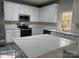 Modern kitchen featuring white cabinets, stainless steel appliances, and a large island at 10735 Essex Hall Dr, Charlotte, NC 28277