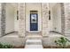 Home's entrance with a blue door and stone columns at 14917 Tamarack Dr, Charlotte, NC 28278