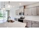 Modern kitchen with gray cabinets, island, and stainless steel appliances at 14917 Tamarack Dr, Charlotte, NC 28278