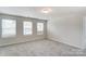 Upstairs bedroom with neutral carpeting and multiple windows at 14917 Tamarack Dr, Charlotte, NC 28278