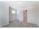 Bright bedroom with grey carpet and access to a closet and bathroom at 14917 Tamarack Dr, Charlotte, NC 28278