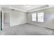 Large bedroom with grey carpet and access to another room at 14917 Tamarack Dr, Charlotte, NC 28278