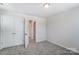 Bright bedroom with grey carpet, double doors, and access to hallway at 14917 Tamarack Dr, Charlotte, NC 28278