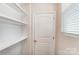 White built-in shelving and a door at 14917 Tamarack Dr, Charlotte, NC 28278