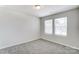 Well-lit bedroom featuring grey carpet and two large windows with blinds at 14917 Tamarack Dr, Charlotte, NC 28278