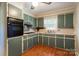 Quaint kitchen with light green cabinets and wood flooring at 961 Shallowbrook Dr, Chester, SC 29706