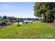 Lakefront backyard with grassy area, dock, and playset at 364 Catalina Dr, Mooresville, NC 28117