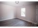 Simple bedroom with light walls, wood-look floors, and a window at 5319 Carden Dr, Charlotte, NC 28227