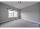 Bright bedroom featuring a large window and plush carpeting at 10881 Greenvale Dr, Harrisburg, NC 28075