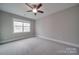 Well-lit bedroom with carpet flooring and ceiling fan at 10881 Greenvale Dr, Harrisburg, NC 28075