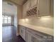 Butler's pantry with white shaker cabinets, quartz countertops, and wine rack at 10881 Greenvale Dr, Harrisburg, NC 28075
