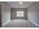 Well-lit bedroom with carpet and a window at 10881 Greenvale Dr, Harrisburg, NC 28075