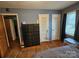 Bedroom with large dresser, double doors, and wood floors at 3608 Crestridge Dr, Charlotte, NC 28217