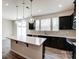 Modern kitchen with island, stainless steel appliances, and sliding door access to patio at 14905 Tamarack Dr, Charlotte, NC 28278