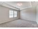 Well-lit bedroom with neutral walls, carpet flooring, and two windows with blinds at 14905 Tamarack Dr, Charlotte, NC 28278