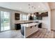 Modern kitchen with island, dark cabinets, and sliding glass door to patio at 14905 Tamarack Dr, Charlotte, NC 28278