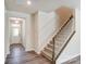 Beige carpeted staircase with wooden railing and entryway view at 14905 Tamarack Dr, Charlotte, NC 28278