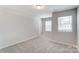 Bright bedroom with neutral walls, carpet, and two windows with blinds at 14905 Tamarack Dr, Charlotte, NC 28278