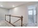 Upstairs hallway with wood railing and carpet flooring at 14905 Tamarack Dr, Charlotte, NC 28278