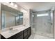 Modern bathroom with double vanity, large mirror, and a walk-in shower at 14905 Tamarack Dr, Charlotte, NC 28278