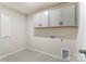 Laundry room with upper cabinets and tile flooring at 14901 Tamarack Dr, Charlotte, NC 28278