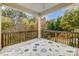 Covered deck with wooded views and patterned rug at 7006 Garden Hill Dr, Huntersville, NC 28078
