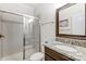 Clean bathroom with shower, toilet, granite vanity, and framed mirror at 7006 Garden Hill Dr, Huntersville, NC 28078