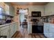Updated kitchen with teal cabinets, stainless steel appliances, and a view to the dining area at 831 College Ave, Shelby, NC 28152