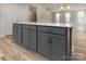 Gray kitchen island with white quartz countertop and ample storage at 2204 Noble Townes Way, Charlotte, NC 28262