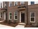 Front entrance of townhome with dark brown door and landscaping at 2208 Noble Townes Way, Charlotte, NC 28262