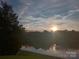 Scenic pond view at sunset with houses in the background at 9538 Skybluff Cir, Huntersville, NC 28078