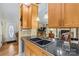 Kitchen with double sink, light wood cabinets, and entryway access at 2929 Matoka Trl, Matthews, NC 28104