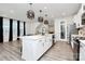 Modern kitchen with white cabinets, large island, and stainless steel appliances at 303 Grove Gate Ln, Indian Trail, NC 28079