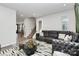 Living room with sectional sofa, coffee table, and view of staircase at 303 Grove Gate Ln, Indian Trail, NC 28079