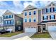 Tan three-story townhome with white garage doors and landscaping at 303 Grove Gate Ln, Indian Trail, NC 28079