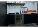 Elegant home bar with black cabinetry, marble backsplash, and wine glass holders at 303 Grove Gate Ln, Indian Trail, NC 28079