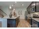 Modern kitchen with dark cabinets, granite island, and stainless steel appliances at 2572 Blue Sky Meadows Dr, Monroe, NC 28110