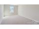 Well-lit bedroom featuring neutral carpeting and a window at 9744 Inkberry Dr, Gastonia, NC 28056