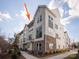 Modern three-story townhome with gray and white exterior, multiple windows, and walkway at 1419 Collier Walk Aly # Csw0208, Charlotte, NC 28205