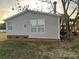 Tan vinyl-sided home with brick base and mature landscaping at 36245 Nugget Rd # 2, New London, NC 28127