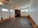 Living room with stone fireplace, wood flooring and shutters at 36245 Nugget Rd # 2, New London, NC 28127