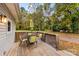 Wooden deck with a table, chairs, and umbrella, overlooking backyard at 627 Brevard St, Statesville, NC 28677