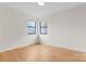 Well-lit bedroom featuring hardwood floors and two windows at 6400 Whitewater Dr, Charlotte, NC 28214