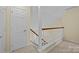 Upstairs hallway with carpet, railing, and door to bedroom at 9109 Agnes Park Ln, Huntersville, NC 28078