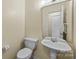 Clean bathroom with pedestal sink, toilet, and mirrored medicine cabinet at 9109 Agnes Park Ln, Huntersville, NC 28078