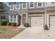 Two story townhome with stone exterior, two car garage, and landscaping at 9510 Birkwood Ct, Charlotte, NC 28278